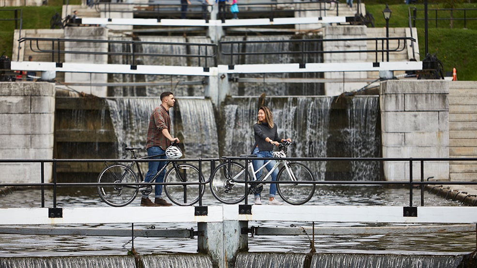 Cyclist crossing the Rideau Canal locks in fall