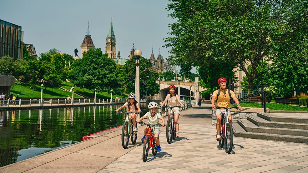 Family cycling on the Rideau Canal in downtown