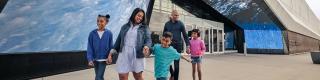 A family of five poses in front of the iconic entrance to the Canada Science and Technology Museum in Ottawa